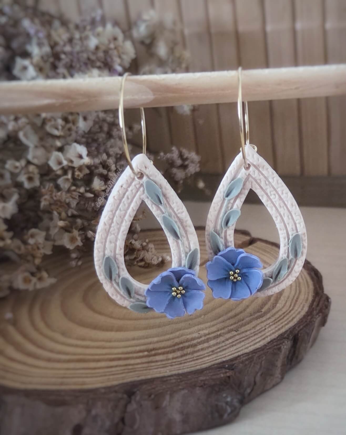 Detalle de flores azules modeladas a mano en pendientes Nomeolvides