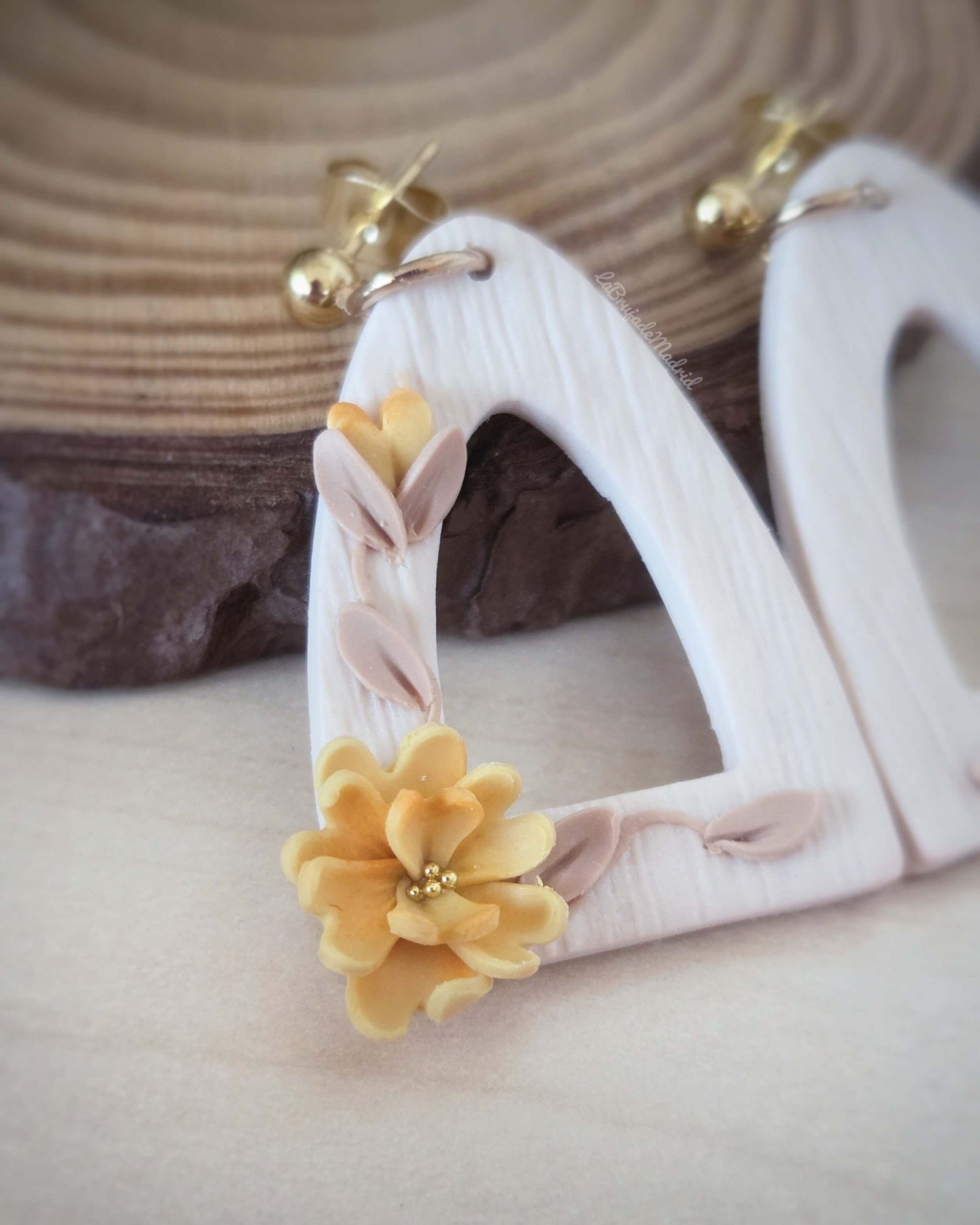 Detalle de flor amarilla modelada a mano en los pendientes Ámbar de arcilla polimérica
