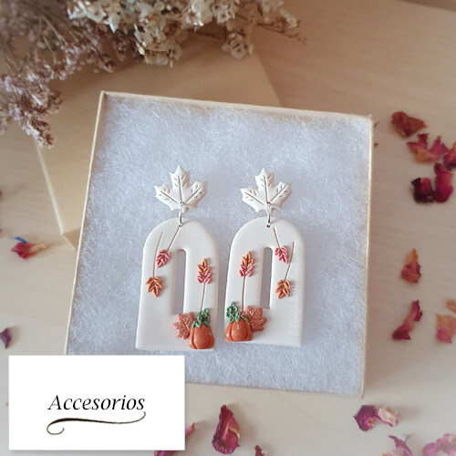 Imagen de unos pendientes decorados con calabazas y hojas. Incluye un cartel donde pone accesorios