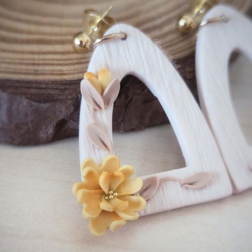 Detalle de flor amarilla modelada a mano en los pendientes Ámbar de arcilla polimérica